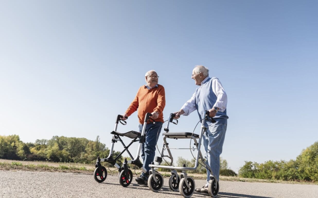 Seniorzy z chodzikami na spacerze Seniorzy z chodzikami na spacerze